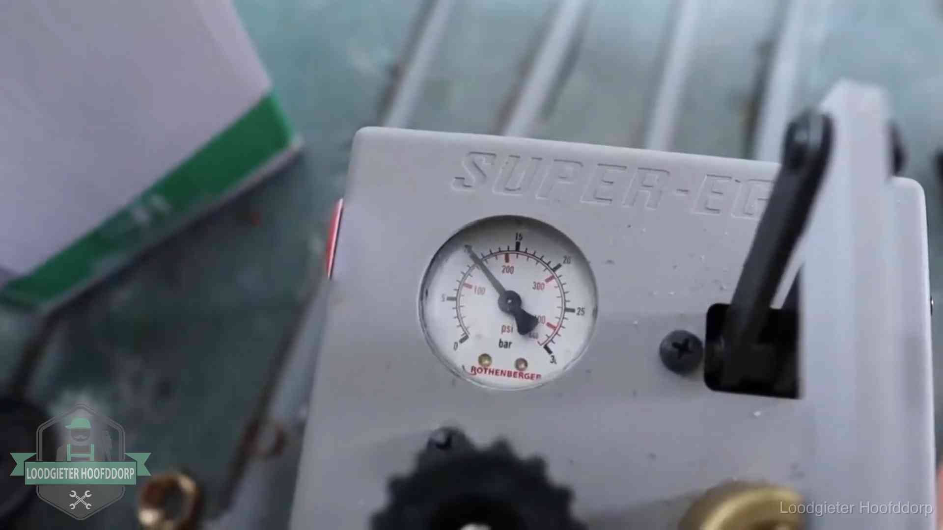 Manometer van een afperspomp bij controle van nieuw leidingwerk in Hoofddorp