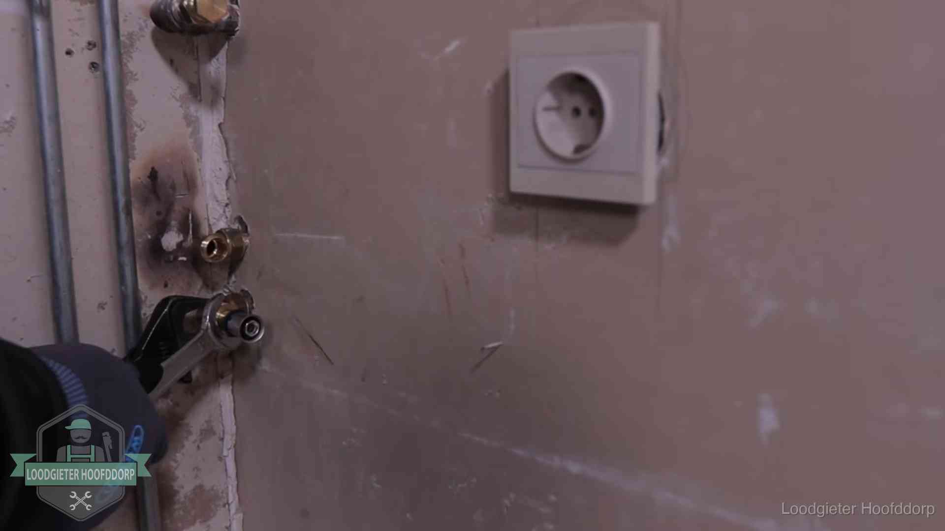 Monteur draait een perskoppeling vast op een leidingaansluiting in Hoofddorp