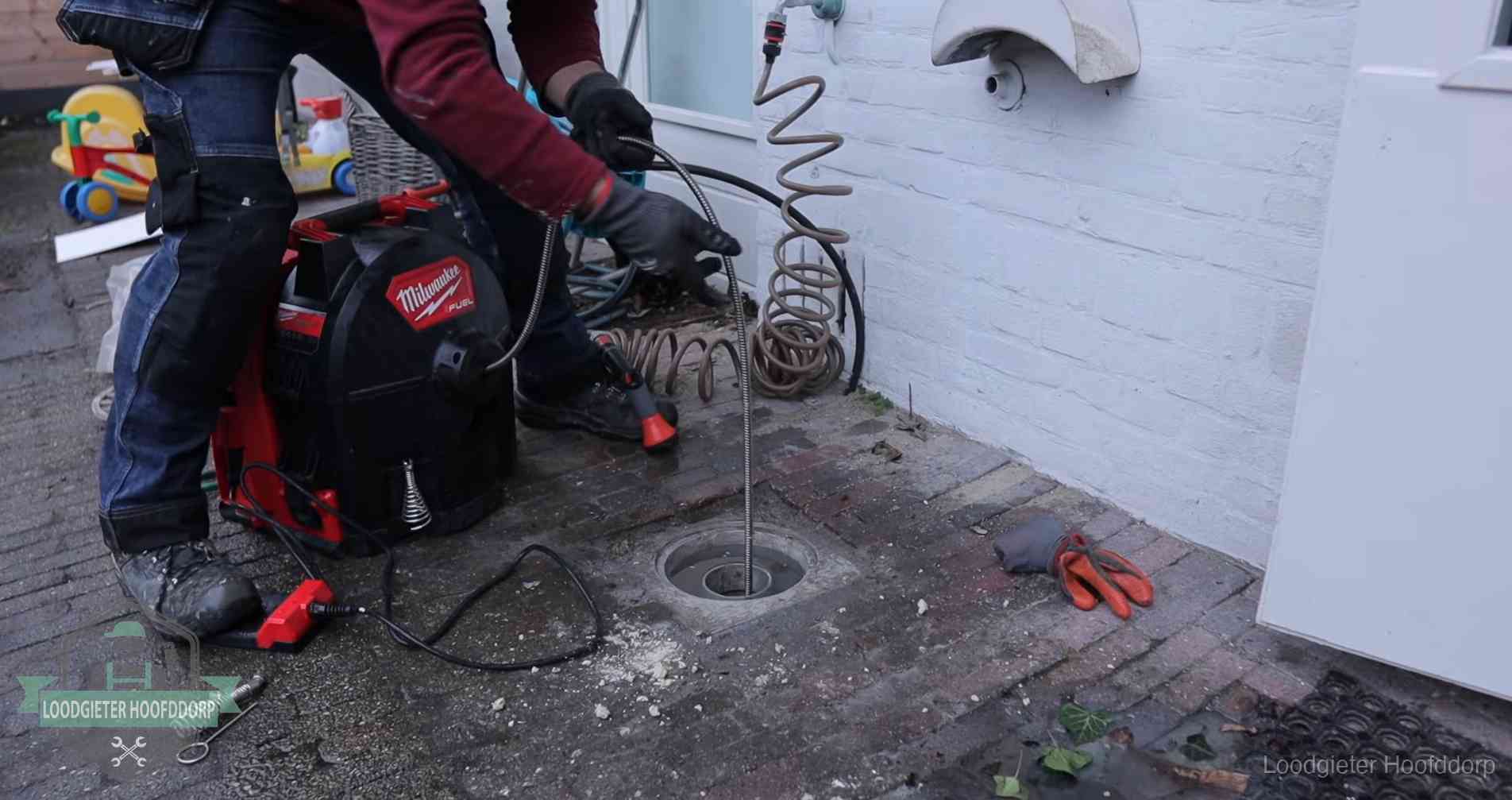 Ontstoppingsputje in de bestrating naast de gevel van een woning in Hoofddorp