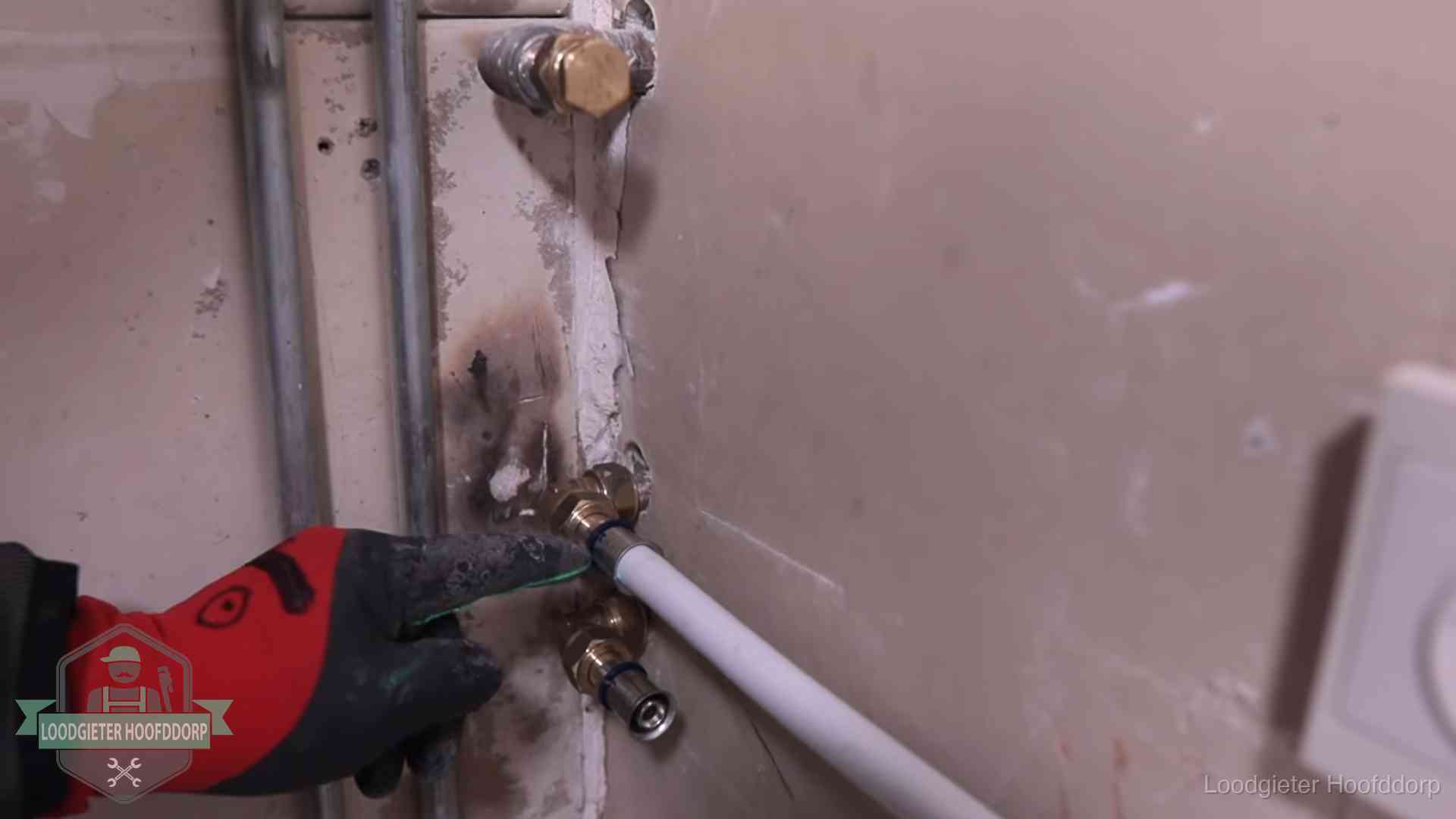 Loodgieter wijst de persfitting op nieuwe muuraansluitingen aan in een woning in Hoofddorp