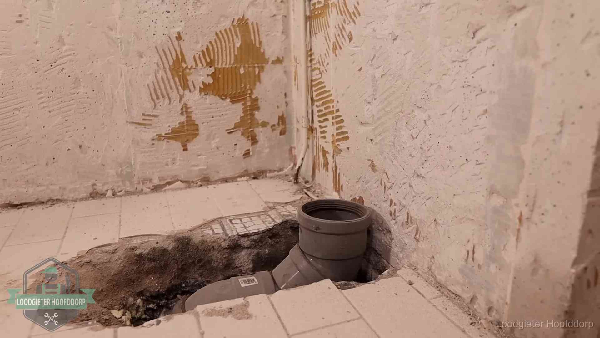 Opengebroken vloer met een nieuwe pvc-rioolbocht in een gegraven sleuf in Hoofddorp