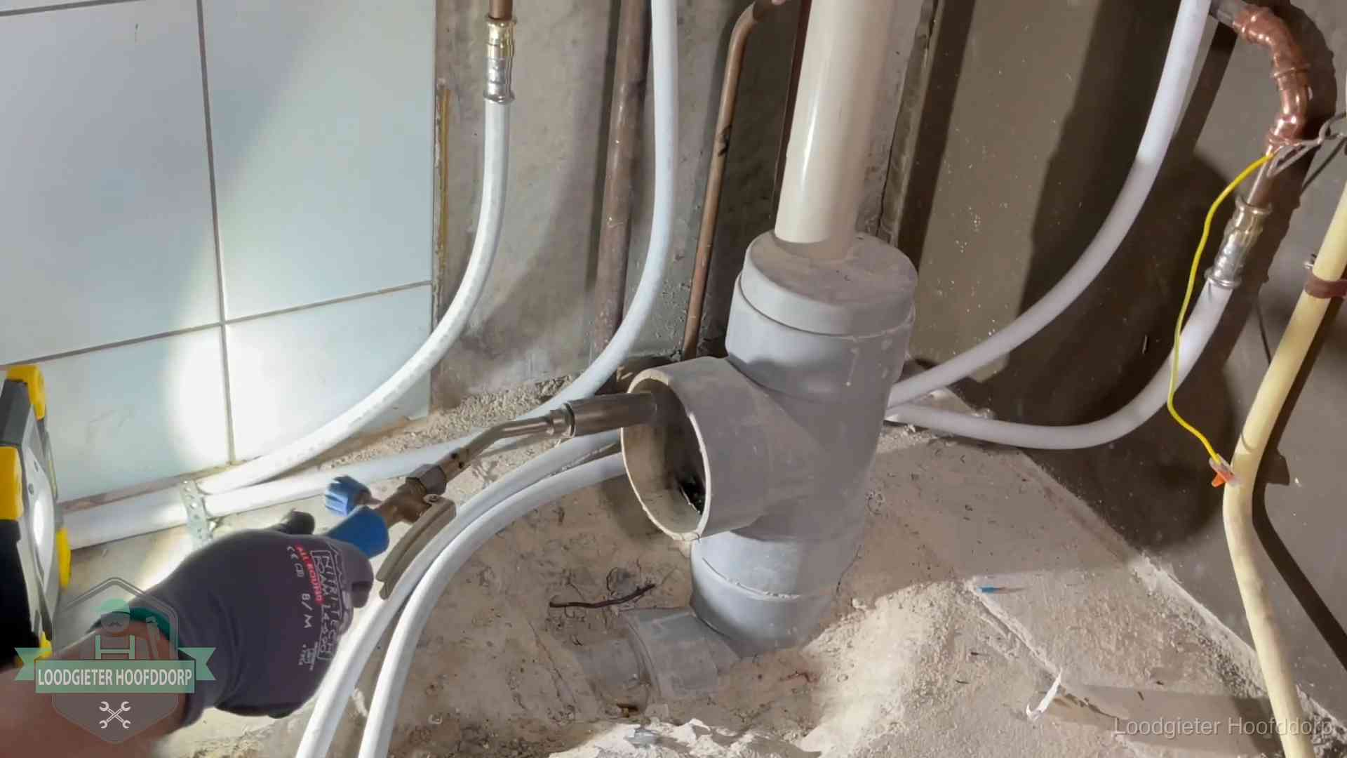 Loodgieter werkt aan leidingen bij de pvc-standleiding van een huurwoning in Hoofddorp