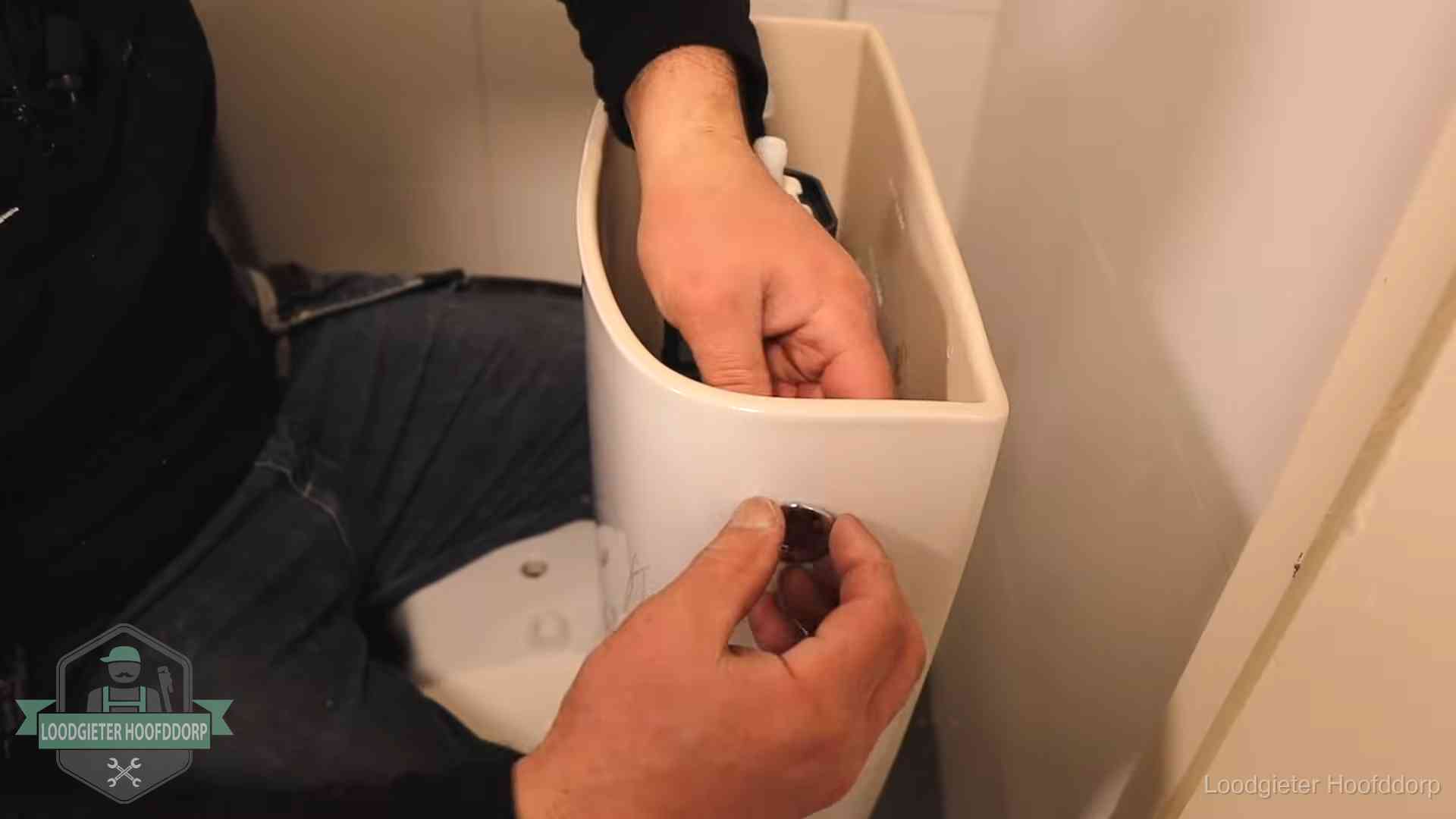 Je wc verstoppingsvrij houden in Hoofddorp Drukknop van een duoblok-stortbak wordt gemonteerd bij een toilet in Hoofddorp